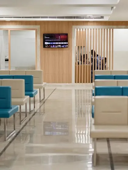 The waiting area in this facility uses a combination of cool blue and neutral beige seating to create a balanced and calming color palette. The layout provides clear pathways and an organized environment for patients and staff.