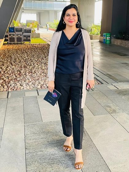 A classic office look. Here I've paired a simple navy satin top with black trousers and a beige long cardigan. This is a perfect example of a smart, layered look for a professional environment.