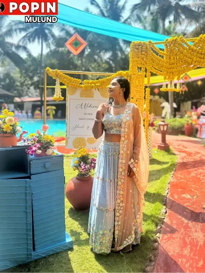 A client looking ethereal at a poolside mehendi ceremony in a light blue embroidered lehenga. The soft colors are perfect for a day event.
