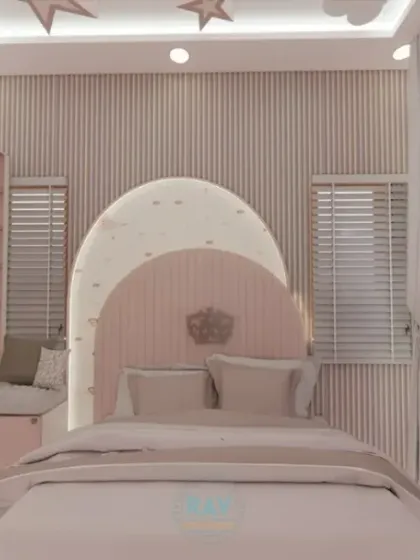 A full view of the pink kids' room, showing the unique arched headboard, study desk, and ample storage.