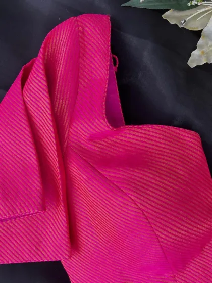 Add a touch of drama to your outfit with this bright pink blouse featuring a statement ruffled sleeve. It's a fun, trendy piece that's perfect for festive celebrations.