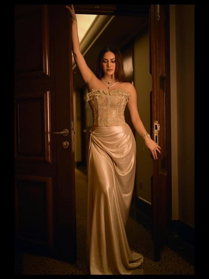 A dramatic, full-length portrait of Amyra Dastur in a doorway. Her pose is powerful and creates a beautiful, elongated silhouette.