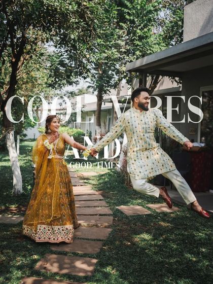 A fun shot of the groom jumping in the air while holding the bride's hand, capturing the high energy of their Haldi day.