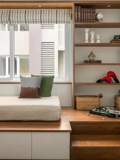 A versatile room from the 'Palaash' project, designed as a mini home office, library, and recreational nook. A custom platform transitions into a bed, complemented by integrated shelving and steps with storage.