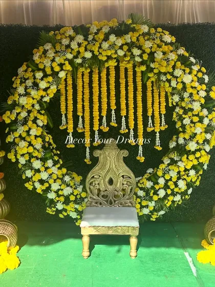 A perfect example of our vibrant Haldi ceremony decor. We created a full circular arch with yellow marigolds and white chrysanthemums, complete with a traditional seat and decorative pots, making for a stunning photo opportunity.