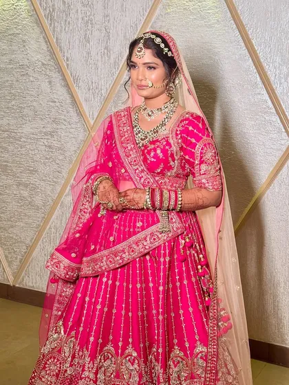 This bride is a vision in pink, wearing a full kundan bridal set. The necklace, matha patti, and nath come together to create a look that is both traditional and breathtakingly beautiful.