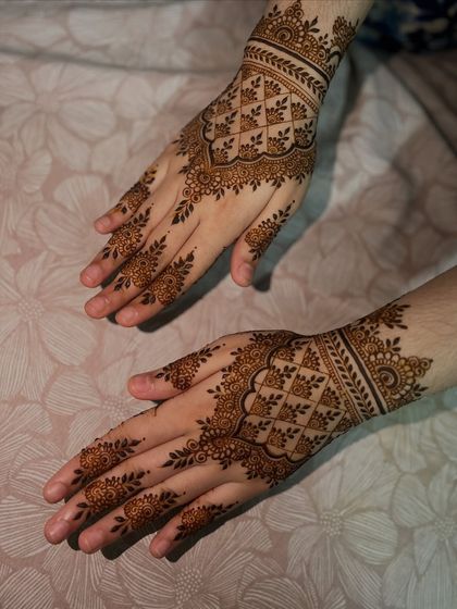 A lighter take on the traditional back-hand design, with a central geometric pattern and delicate floral vines on the fingers.