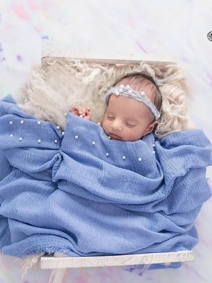 The purest serenity. I specialize in creating a safe and peaceful environment to capture your newborn in their most natural state. This little one, swaddled in soft blue and adorned with delicate pearls, is a perfect example of the timeless, artful portraits I create.
