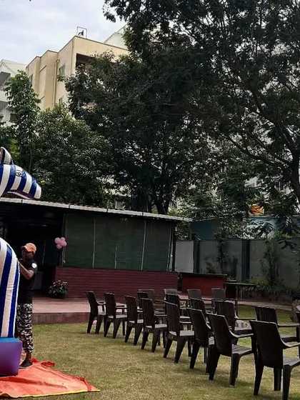 An outdoor butterfly-themed party that includes a large inflatable bouncy castle for entertainment.