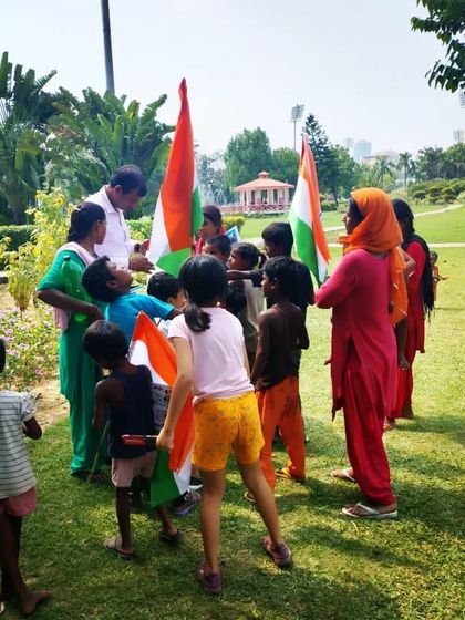 Distributing the national flag to children. Instilling a sense of patriotism and civic duty in the next generation is crucial.