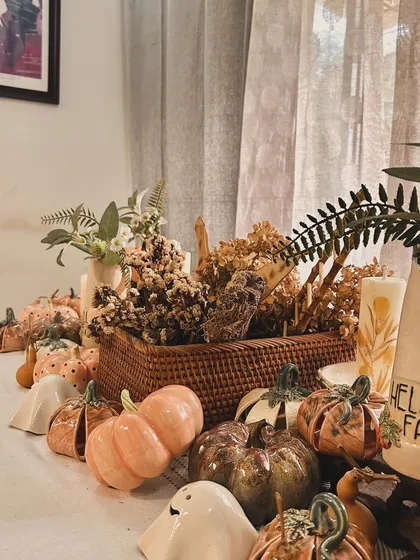 A wide shot of my autumn tablescape, complete with ceramic pumpkins, friendly ghosts, dried flowers, and candles. It's everything I love about this cozy season.