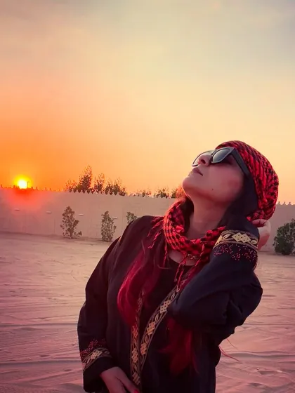 Soaking in the last rays of the sun in the desert. I layered a traditional black abaya over my outfit for some of the pictures to get the full experience.