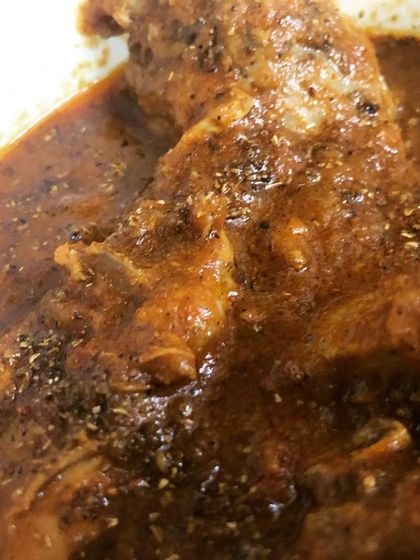 A close-up shot of a tender piece of chicken from our Chicken Chatkaredar curry.