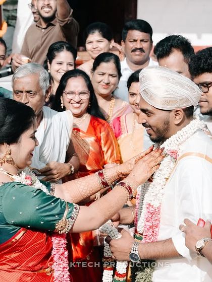 A heartwarming candid photo capturing the emotions of family members as they participate in a traditional ritual with the groom during a South Indian wedding.