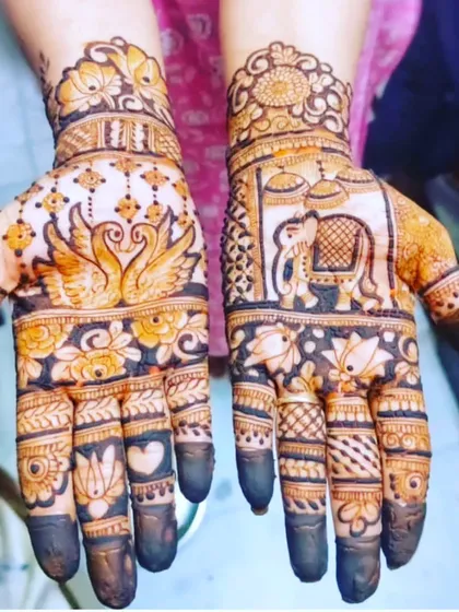 A lovely design for an engagement or wedding event, featuring kissing swans and an elephant in a doli (palanquin). The dark fingertips are a traditional finishing touch.
