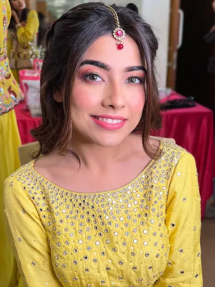 A bright and happy Haldi portrait. Her smile is infectious, and the simple, glowing makeup lets her joy be the focus.