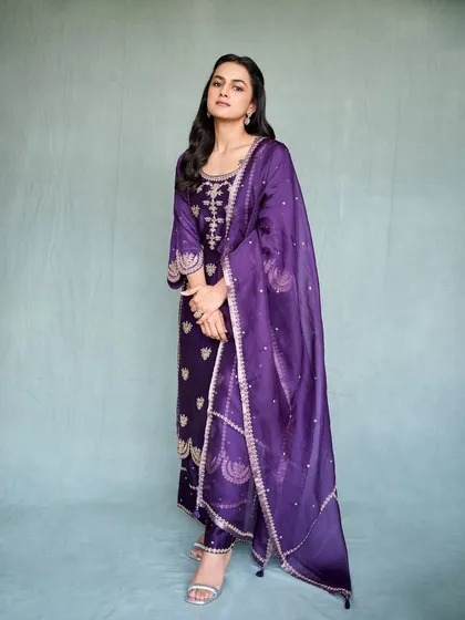 Shraddha Srinath looks radiant in this deep purple salwar suit for her movie promotions. The gold embroidery provides a rich contrast, making it a regal and elegant look for any formal occasion.