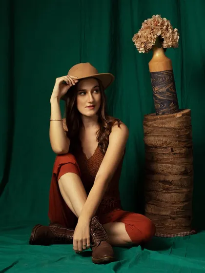 A full-length seated pose. This is a great way to showcase the entire outfit, including the boots, in a natural way.