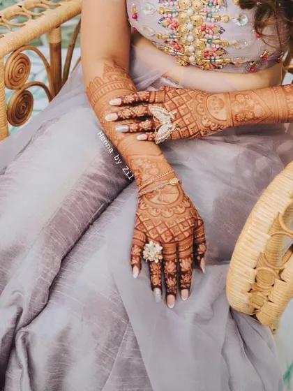 A full view of the bride's mehendi, showing off the fantastic stain color that complements her pastel outfit.