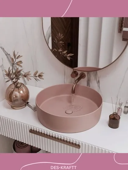 We transform bathrooms into personal spa-like experiences. This design uses a soft blush vessel sink as a focal point, set against a clean marble backdrop and a ribbed vanity, proving that even compact spaces can be filled with elegance and character.