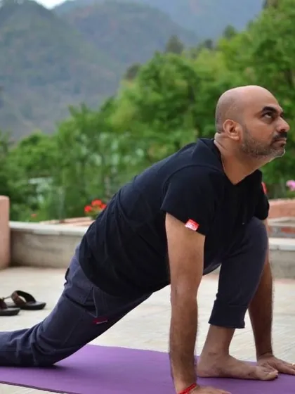 A student practices Ashwa Sanchalanasana (Equestrian Pose) on a rooftop with the mountains as a witness. Practicing outdoors amplifies the benefits of yoga.