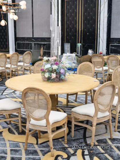 Simple, elegant seating for a chic event. The classic wooden chairs with cane backing are paired with a simple floral centerpiece, proving that beauty is often in simplicity.