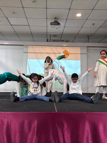 A dynamic acrobatic pose during the Republic Day dance performance, showcasing the students' flexibility and teamwork.