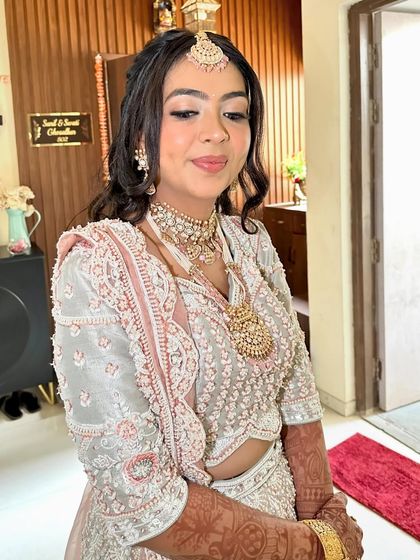 This off-white and pink lehenga features exquisite handwork. It's a delicate and feminine piece, perfect for a bride's engagement or Roka ceremony.