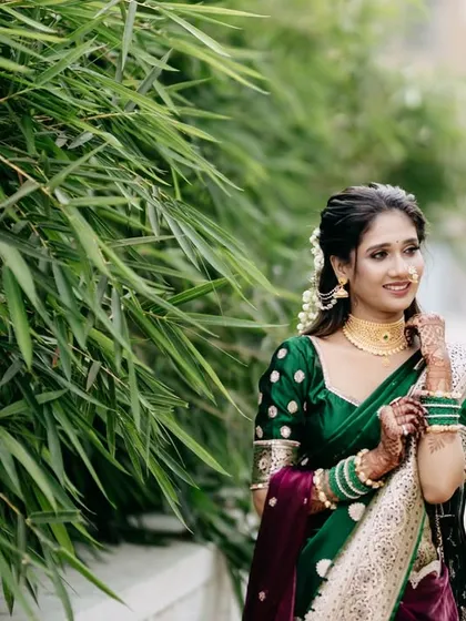 A classic three-quarter portrait of the Marathi bride. She looks away from the camera, creating a candid and thoughtful pose that highlights her traditional jewelry and hairstyle.