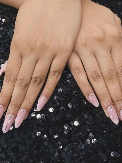 Simple yet stunning. This soft pink manicure is elevated with delicate silver line work and strategically placed rhinestones for a touch of sparkle.
