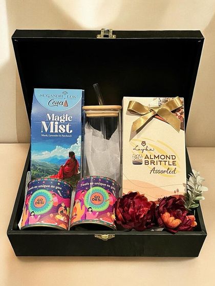 A beautiful Diwali gift set presented in a premium black box. It contains gourmet snacks, scented products, and a glass tumbler, perfect for delighting clients or employees.