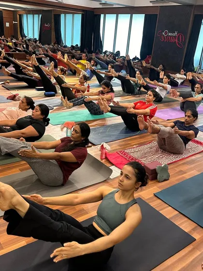 The core-strengthening challenge of Navasana (Boat Pose) during a group practice. We hold each other up with our collective energy.