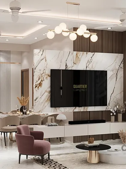 A full view of the living and dining space at Gaur Saundaryam, showing how the TV unit acts as a partition. The design uses a mix of wood, marble, and louvers to create a warm, contemporary, and cohesive environment.