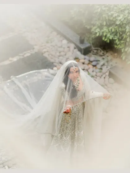 A dreamy and ethereal bridal portrait, with the bride looking through her soft white veil.