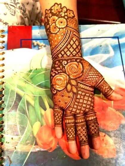 A lovely single-hand design featuring rose motifs and geometric jaali patterns. This is a quick yet elegant option for guests at a large event.