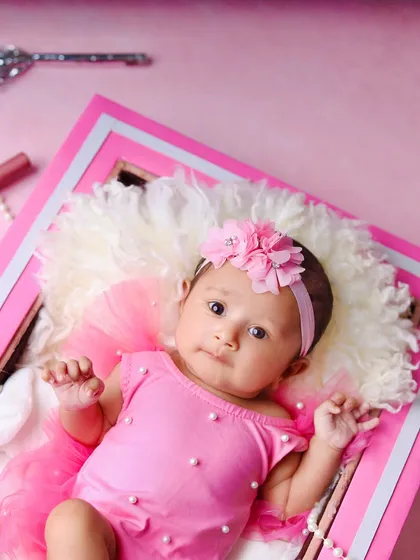 A close-up portrait from the Barbie-themed shoot, focusing on the baby's sweet face and the all-pink, glamorous setup.