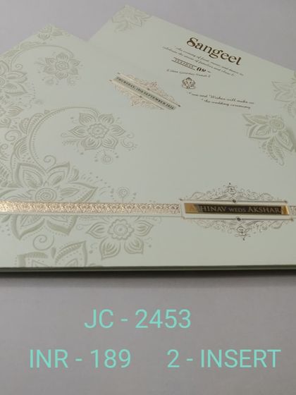 This off-white invitation features a modern, oversized floral pattern embossed in a pearl finish. A simple gold band with the couple's names completes this chic and contemporary design.