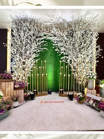 A beautiful photo corner with a backdrop of white cherry blossom trees and illuminated golden poles. It's a perfect blend of natural beauty and modern lighting.