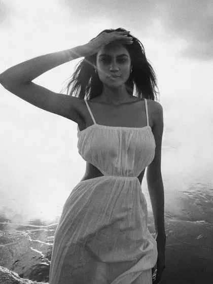 A high-contrast black and white version from the beach shoot. The bright sun reflecting on the water creates a sparkling, almost abstract background.