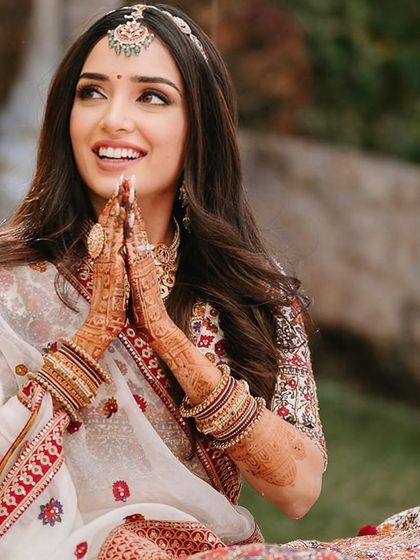 A candid moment of prayer. The bride's makeup is soft and respectful of the traditional ceremony.