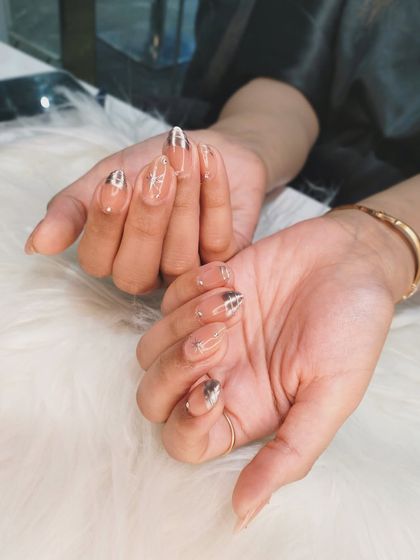 A full hand view of the celestial chrome nail art, showing how the stars and silver tips create a cohesive, dreamy look.