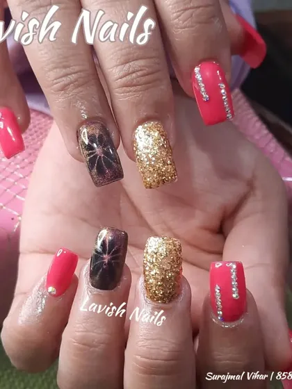 A playful and colorful set with pink, gold glitter, and spider-gel art accent nails.