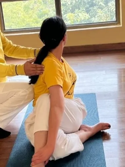 Providing hands-on assistance in an Asana Correction workshop. I help students refine their postures, like this spinal twist, to ensure proper alignment and deepen the benefits of the pose.
