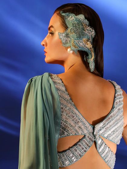 A close-up on the back of an embellished blouse and a statement hair accessory. This shot emphasizes the incredible detail and craftsmanship of the pieces.