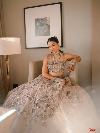 A full-length portrait of the bride, looking elegant and poised in her stunning Sangeet lehenga.