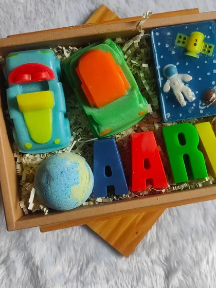 A custom kids' hamper for Aarav, featuring car, space, and letter soaps, along with a bath bomb.