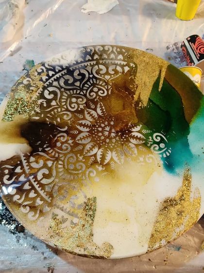 This is a glimpse of an alcohol ink resin art piece in progress. I love how the earthy tones and gold leaf combine with the intricate mandala stencil to create a rich, textured artwork.