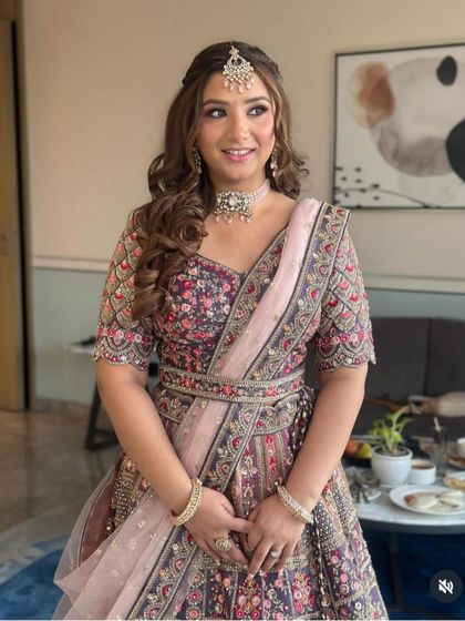 A front view of the client, showing how the half-up hairstyle with a maang tikka creates a balanced and elegant look.