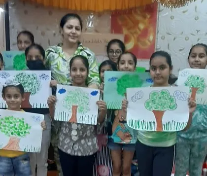 Learning to draw from nature is a key part of our curriculum. Here, a group of students proudly holds up their unique tree drawings, created using a fun sponge painting technique.