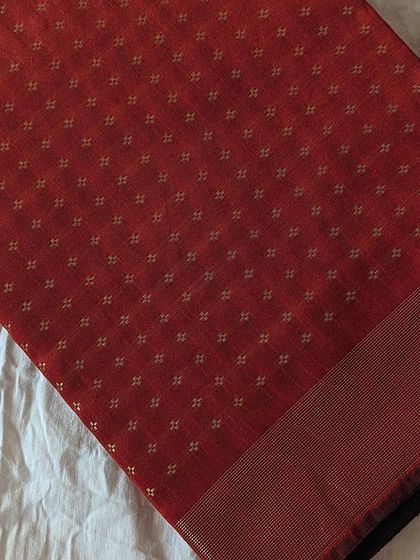 This brick red semi raw silk saree with gold butti is a warm and inviting color, perfect for festive gatherings.